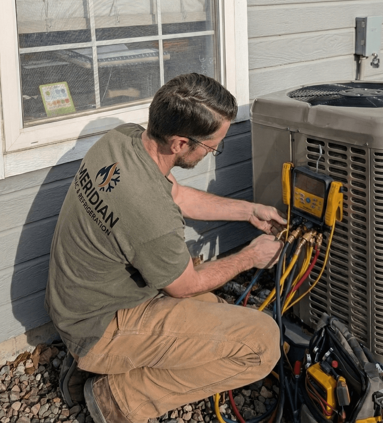 HVAC technician servicing air conditioning in Kuna